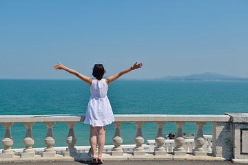 Image showing happy young woman with spreading arms to sky