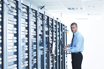 Image showing businessman with laptop in network server room