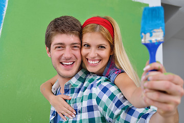 Image showing happy couple paint wall at new home