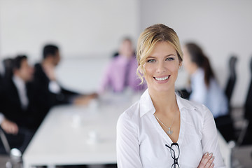 Image showing business woman standing with her staff in background