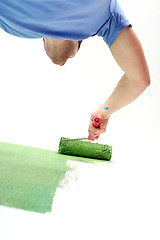 Image showing handsome young man paint white wall in color