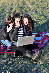 Image showing group of teens working on laptop outdoor