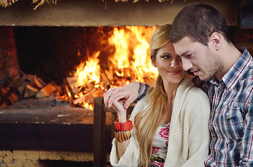 Image showing Young romantic couple sitting and relaxing in front of fireplace