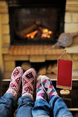 Image showing Young romantic couple relax on sofa in front of fireplace at hom