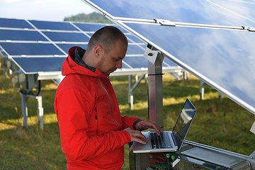 Image showing engineer using laptop at solar panels plant field