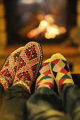 Image showing Young romantic couple sitting and relaxing in front of fireplace