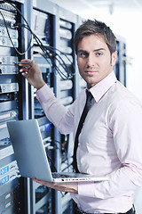 Image showing businessman with laptop in network server room