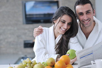 Image showing Happy couple reading the newspaper in the kitchen at breakfast