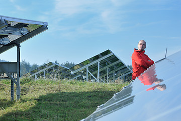 Image showing engineer using laptop at solar panels plant field