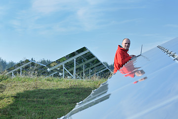 Image showing engineer using laptop at solar panels plant field