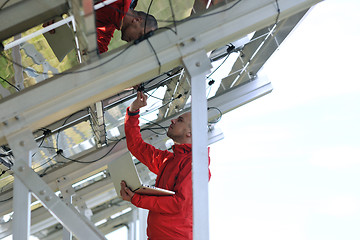 Image showing engineer using laptop at solar panels plant field