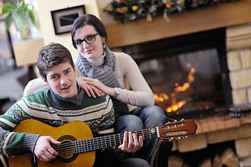 Image showing Young romantic couple relax on sofa in front of fireplace at hom