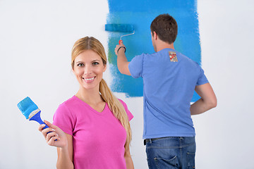 Image showing happy couple paint wall at new home