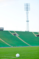 Image showing Soccer ball on grass at goal and stadium in background