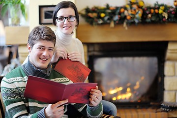 Image showing Young romantic couple relax on sofa in front of fireplace at hom