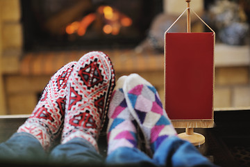 Image showing Young romantic couple sitting and relaxing in front of fireplace