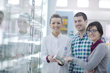 Image showing pharmacist suggesting medical drug to buyer in pharmacy drugstor