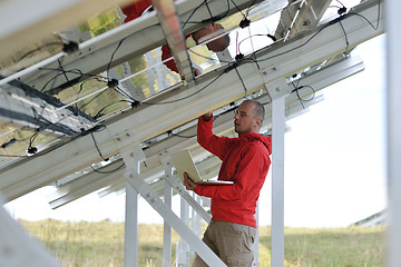 Image showing engineer using laptop at solar panels plant field