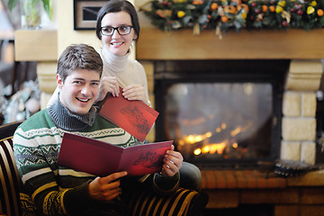 Image showing Young romantic couple sitting and relaxing in front of fireplace