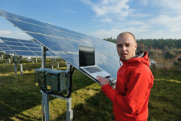 Image showing engineer using laptop at solar panels plant field