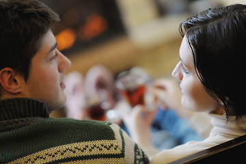 Image showing Young romantic couple sitting and relaxing in front of fireplace