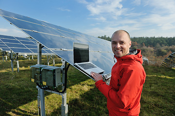 Image showing engineer using laptop at solar panels plant field