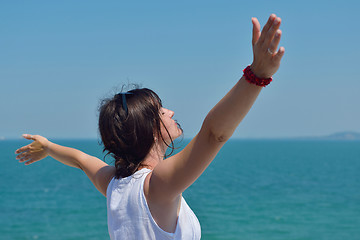 Image showing happy young woman with spreading arms to sky