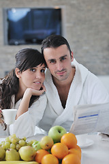 Image showing Happy couple reading the newspaper in the kitchen at breakfast