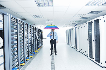 Image showing businessman hold umbrella in server room