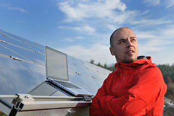 Image showing engineer using laptop at solar panels plant field