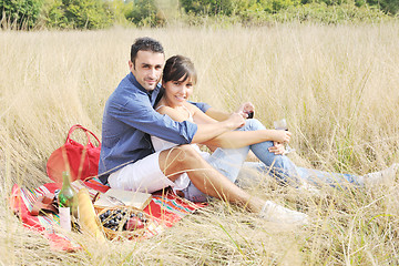 Image showing happy couple enjoying countryside picnic in long grass