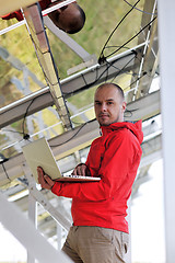 Image showing engineer using laptop at solar panels plant field