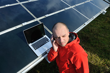 Image showing engineer using laptop at solar panels plant field