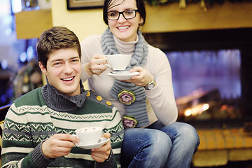 Image showing Young romantic couple sitting and relaxing in front of fireplace