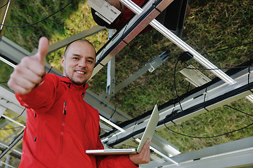 Image showing engineer using laptop at solar panels plant field