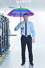 Image showing businessman hold umbrella in server room