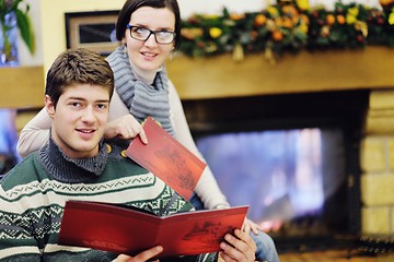 Image showing Young romantic couple relax on sofa in front of fireplace at hom