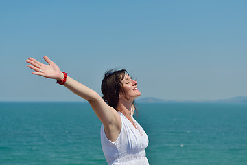 Image showing happy young woman with spreading arms to sky