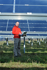 Image showing engineer using laptop at solar panels plant field