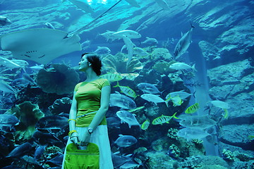 Image showing young woman with big aquarium in backgrond