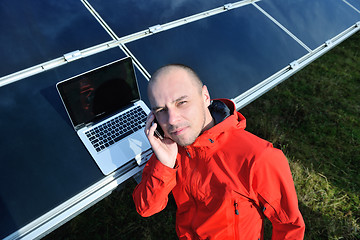 Image showing engineer using laptop at solar panels plant field