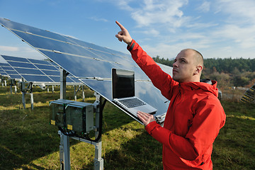 Image showing engineer using laptop at solar panels plant field