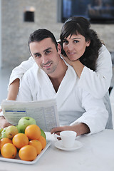 Image showing Happy couple reading the newspaper in the kitchen at breakfast