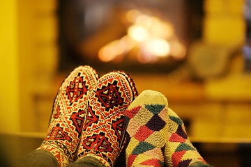 Image showing Young romantic couple sitting on sofa in front of fireplace at h