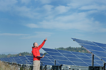 Image showing engineer using laptop at solar panels plant field