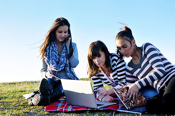 Image showing group of teens working on laptop outdoor