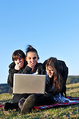 Image showing group of teens working on laptop outdoor