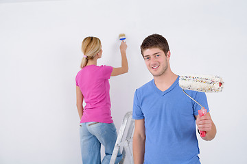 Image showing happy couple paint wall at new home