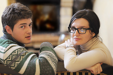 Image showing Young romantic couple sitting and relaxing in front of fireplace