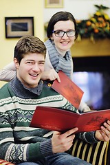 Image showing Young romantic couple relax on sofa in front of fireplace at hom